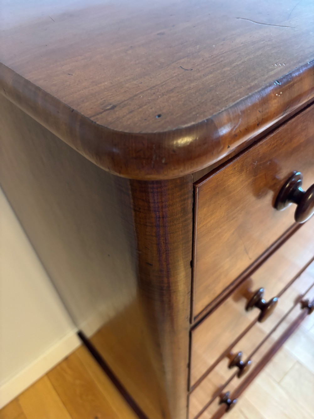 A mid-Victorian mahogany chest of drawers featuring four full-width drawers with turned wooden knobs set on a continuous plinth base. View IV