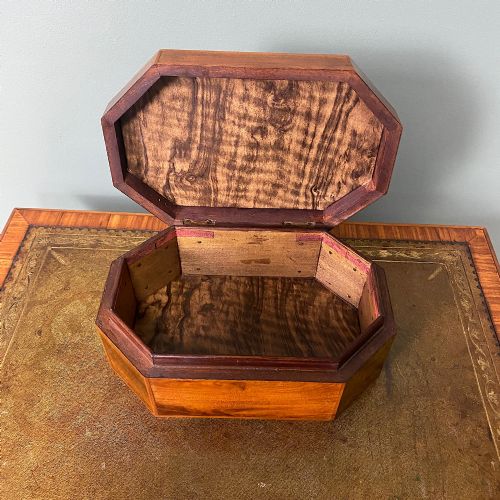 fig 2. An octagonal Victorian warm brown wooden box featuring a central starburst wood inlay on the hinged lid.