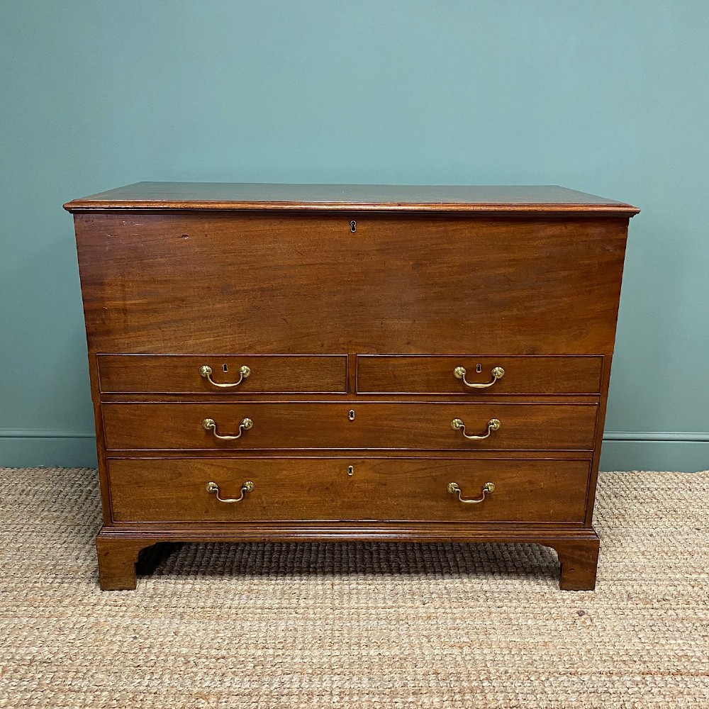 A Georgian mahogany mule chest featuring a top hinged lid over two short drawers and two long drawers with brass swan-neck handles on bracket feet.