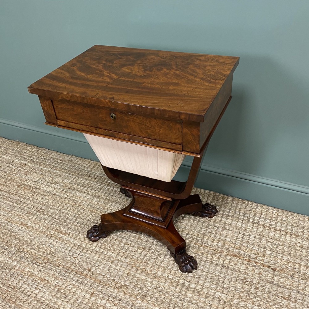 A William IV flame mahogany work table featuring a top drawer, pleated fabric work basket, U-shaped pedestal support, and carved claw feet. View III