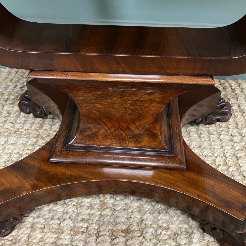 A William IV flame mahogany work table featuring a top drawer, pleated fabric work basket, U-shaped pedestal support, and carved claw feet. View IV