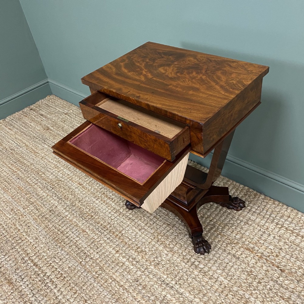 A William IV flame mahogany work table featuring a top drawer, pleated fabric work basket, U-shaped pedestal support, and carved claw feet. View VII