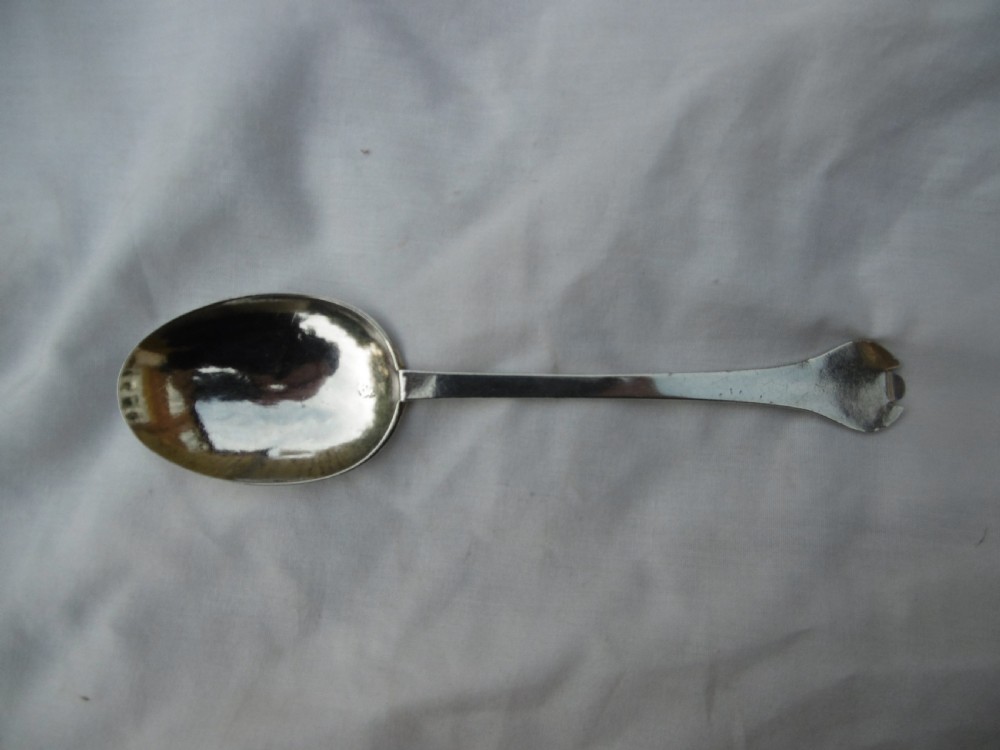 An antique silver trefid spoon featuring a notched three-lobed handle end with hand-engraved initials and an oval bowl. View IV