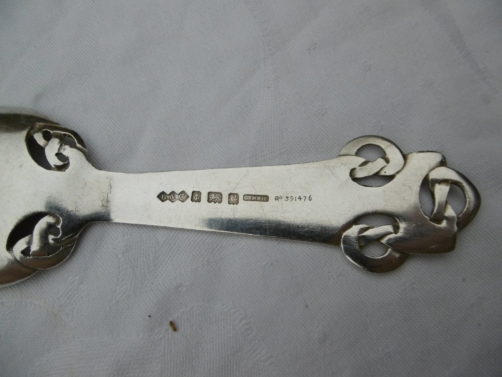 An Edwardian sterling silver spoon featuring stylised Celtic knotwork at the handle terminal and junction, with an engraved monogram inside the oval bowl. View II