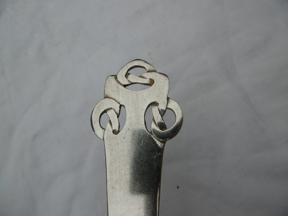 An Edwardian sterling silver spoon featuring stylised Celtic knotwork at the handle terminal and junction, with an engraved monogram inside the oval bowl. View III