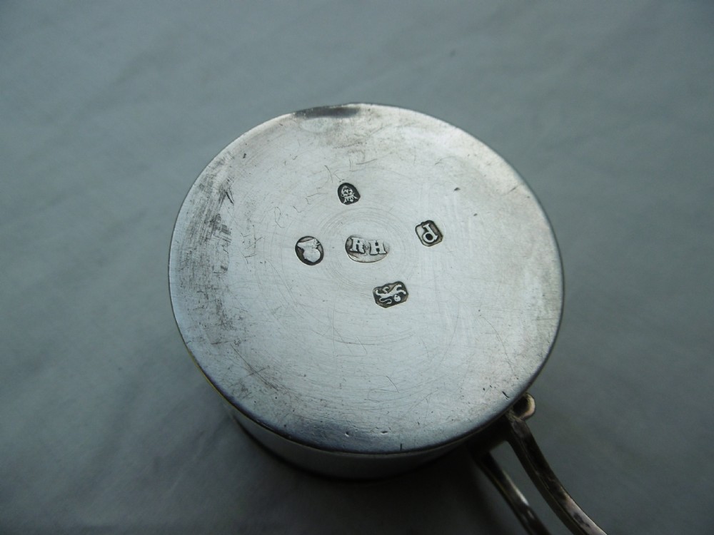 A small cylindrical Georgian sterling silver bougie box with a side loop handle and a circular hole in the lid. View II