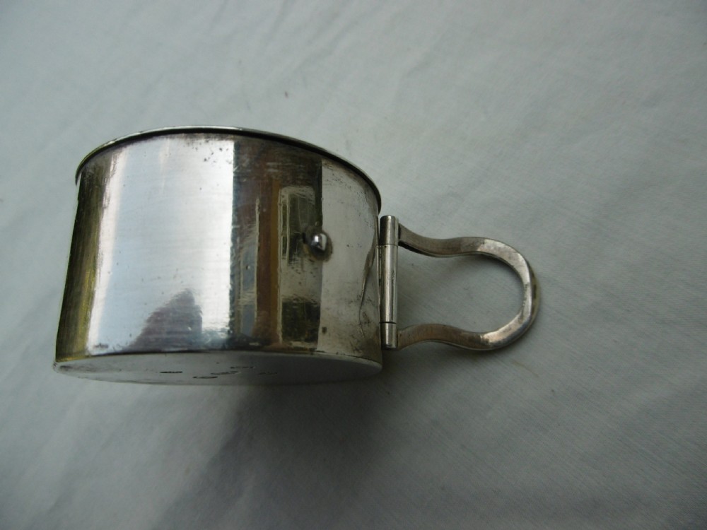 A small cylindrical Georgian sterling silver bougie box with a side loop handle and a circular hole in the lid. View III