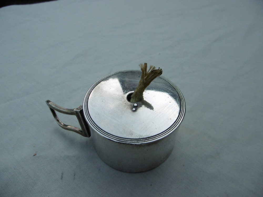 A small cylindrical Georgian sterling silver bougie box with a side loop handle and a circular hole in the lid. View V