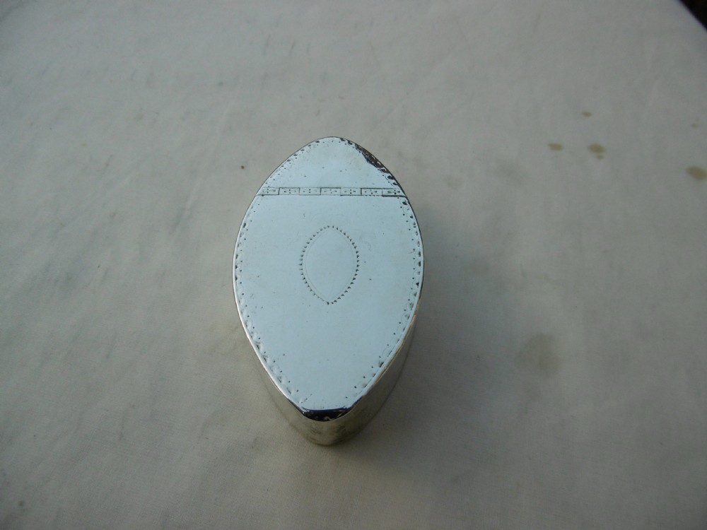 An 18th-century navette-shaped sterling silver snuff box featuring bright-cut engraved borders and a central oval cartouche.