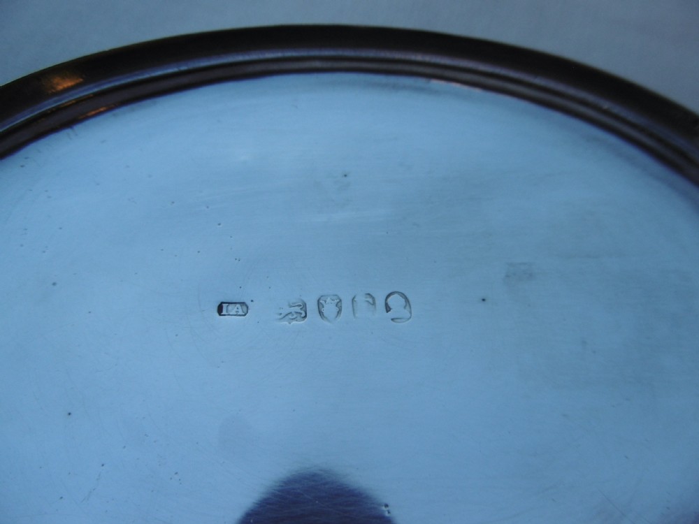 An open oval Georgian sterling silver tobacco box displaying stamped British hallmarks inside the lid and base. View III