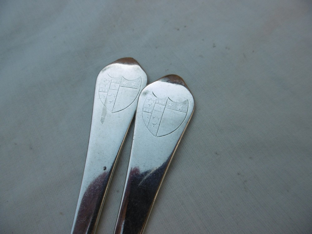A pair of antique silver table forks featuring three tines and dognose handles engraved with armorial crests. View III