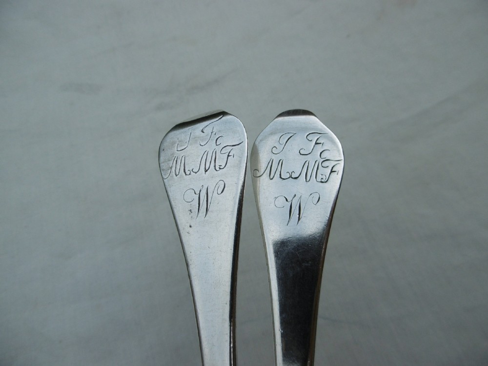 A pair of 1706 Scottish Queen Anne sterling silver dognose tablespoons featuring rat-tail bowl supports and engraved initials on the handle terminals. View IV