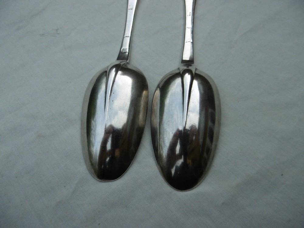 A pair of 1706 Scottish Queen Anne sterling silver dognose tablespoons featuring rat-tail bowl supports and engraved initials on the handle terminals. View V