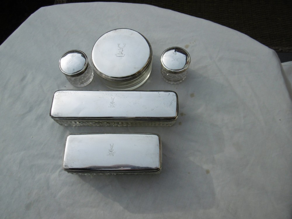 A five-piece Georgian sterling silver and cut glass dressing table set featuring engraved stag crests on silver lids. View II
