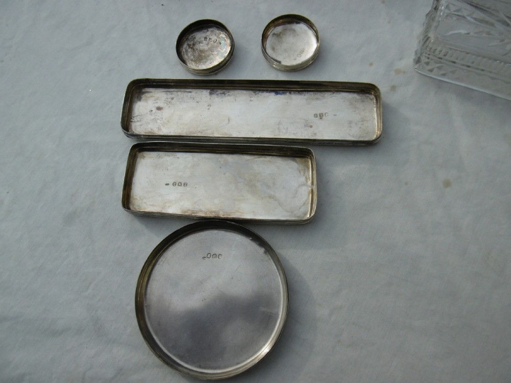 A five-piece Georgian sterling silver and cut glass dressing table set featuring engraved stag crests on silver lids. View VI