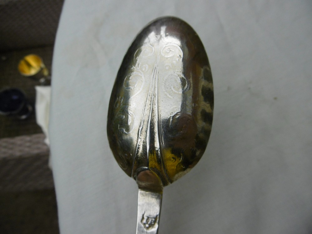 Reverse view of a silver tablespoon dated 1707 with a lace-back pattern and hallmarks along the handle. View IV