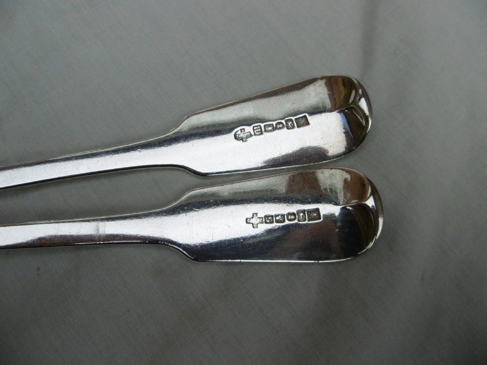 A pair of Georgian sterling silver soup ladles featuring Fiddle pattern handles engraved with crests and deep round silver bowls. View III