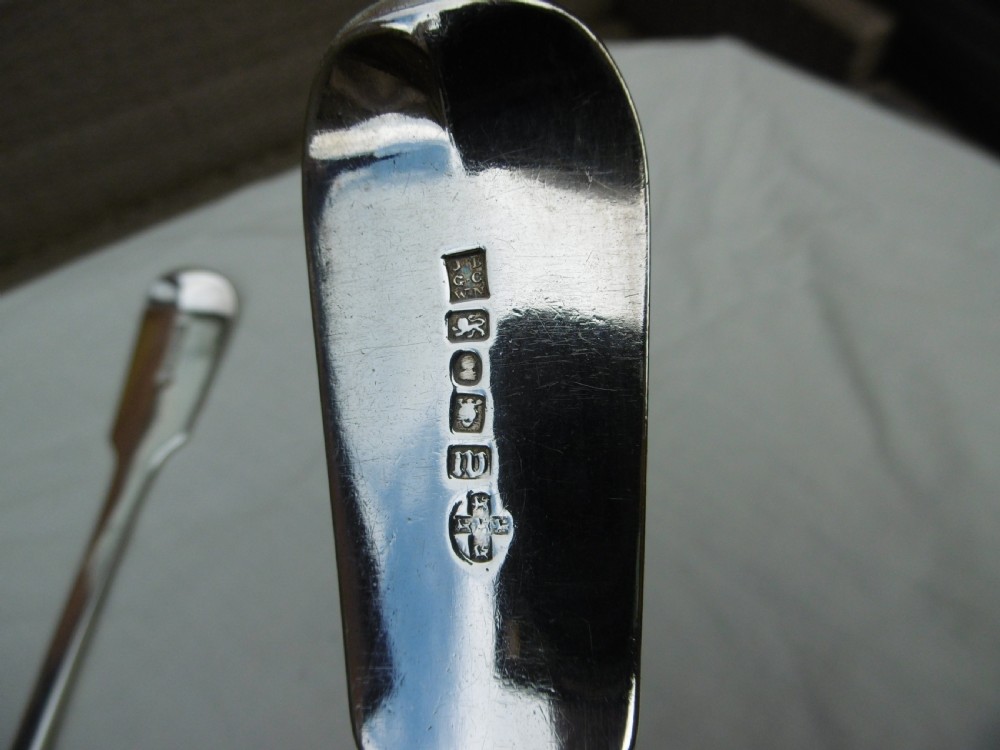 A pair of Georgian sterling silver soup ladles featuring Fiddle pattern handles engraved with crests and deep round silver bowls. View V