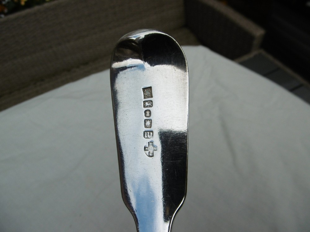 A pair of Georgian sterling silver soup ladles featuring Fiddle pattern handles engraved with crests and deep round silver bowls. View VI