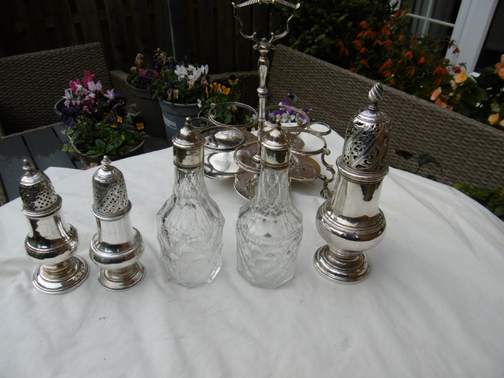 An 18th-century Georgian sterling silver Warwick cruet frame holding silver casters and cut glass bottles set upon shell-form feet. View IV