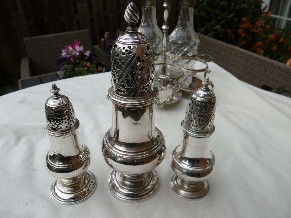 An 18th-century Georgian sterling silver Warwick cruet frame holding silver casters and cut glass bottles set upon shell-form feet. View VI
