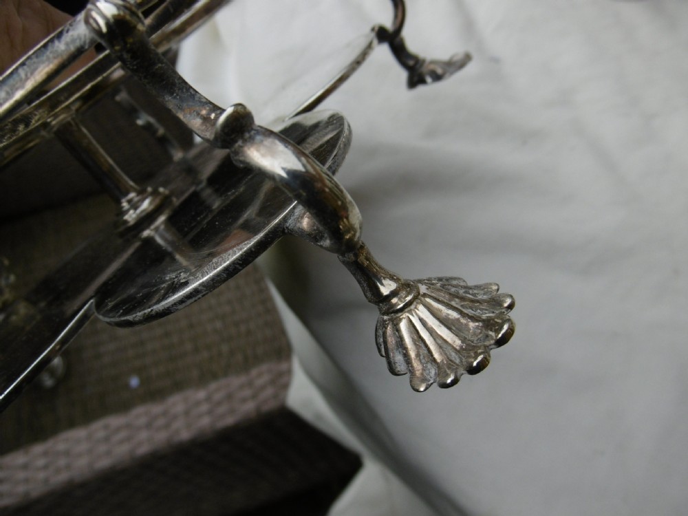 An 18th-century Georgian sterling silver Warwick cruet frame holding silver casters and cut glass bottles set upon shell-form feet. View XII