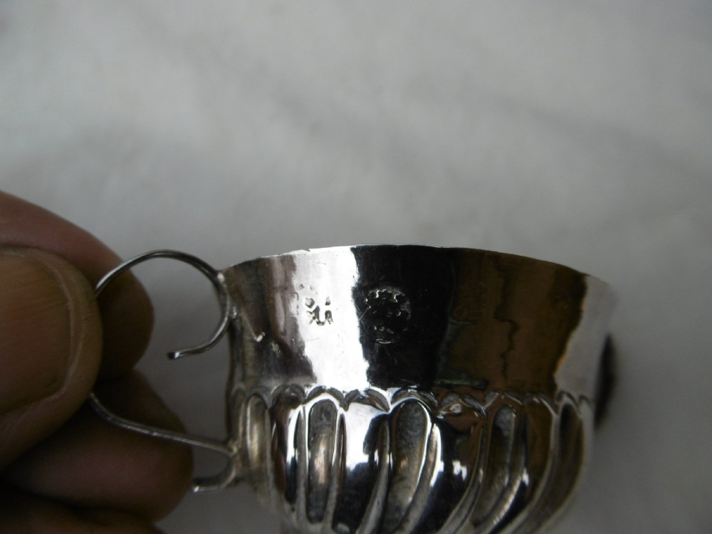 A small late 17th-century silver porringer featuring two wire handles and spiral fluted embossing around the lower half of the bowl. View IV