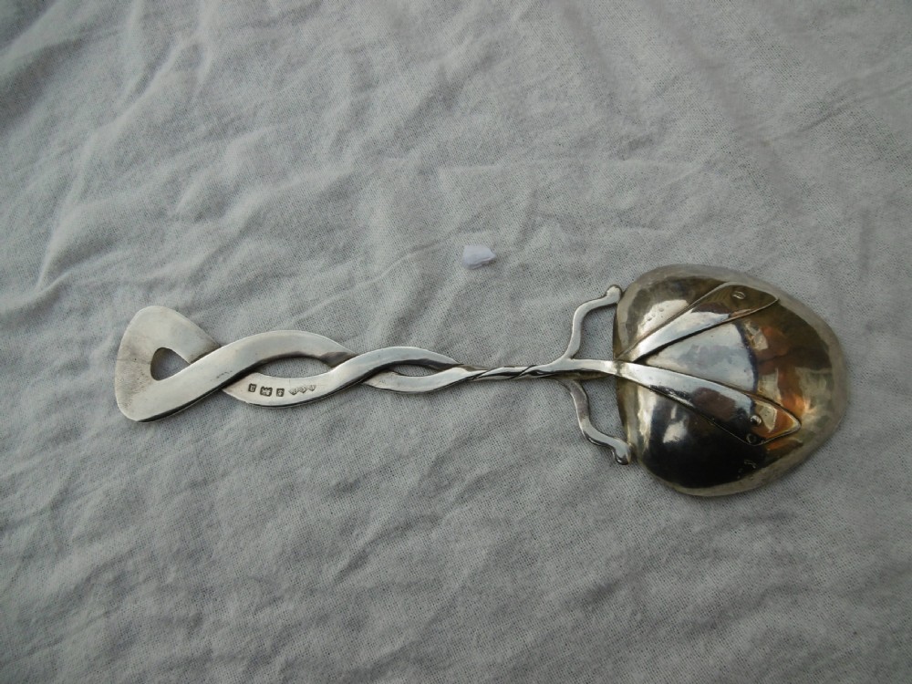 An Arts and Crafts sterling silver spoon with a twisted Celtic knot handle and a planished heart-shaped bowl. View II