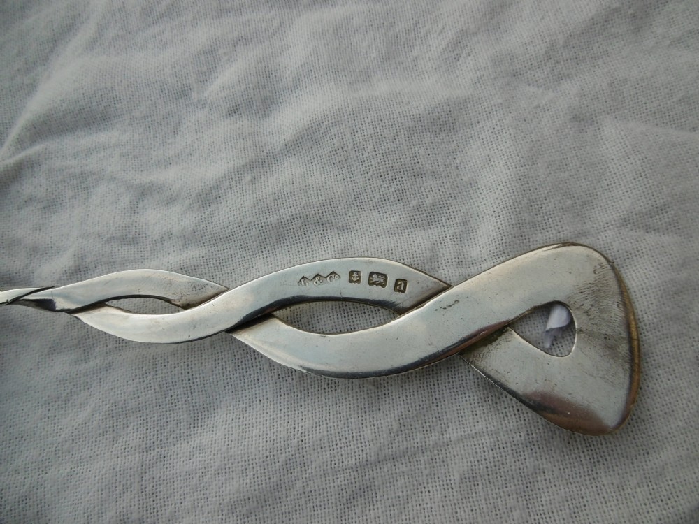 An Arts and Crafts sterling silver spoon with a twisted Celtic knot handle and a planished heart-shaped bowl. View III