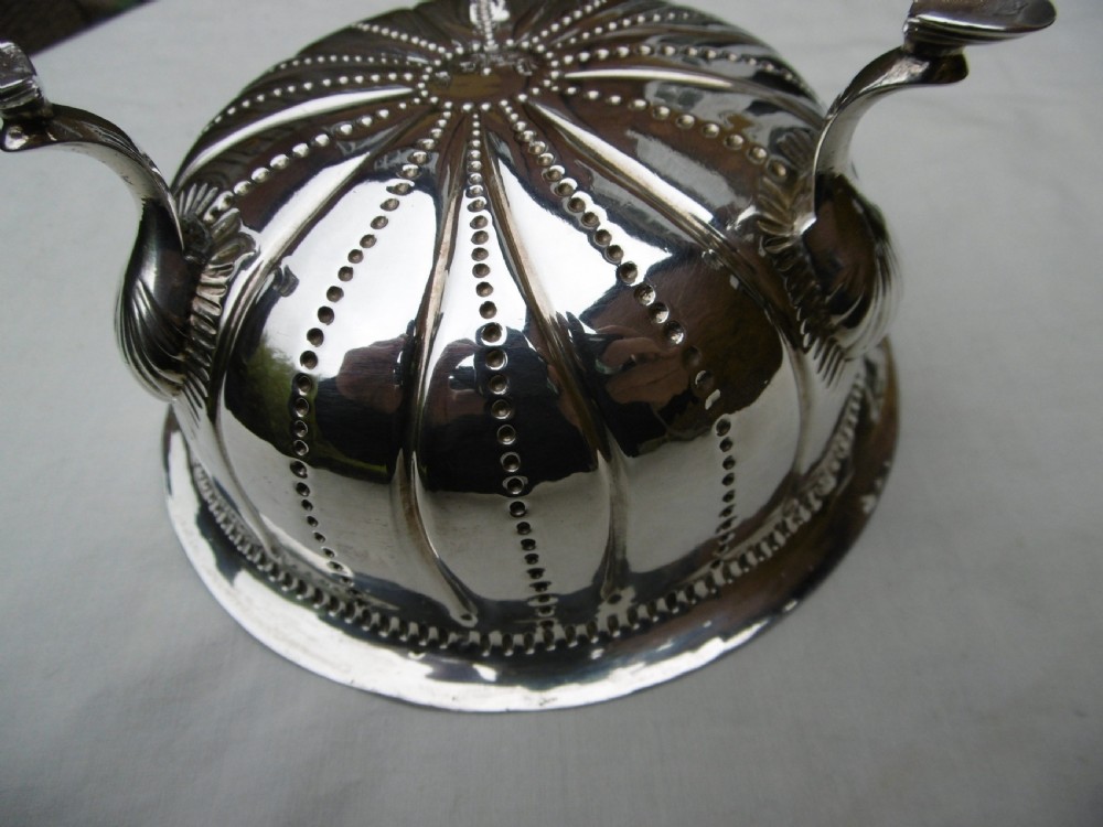 An antique George II sterling silver footed bowl featuring fluted sides, bead details, and shell-motif legs. View IV