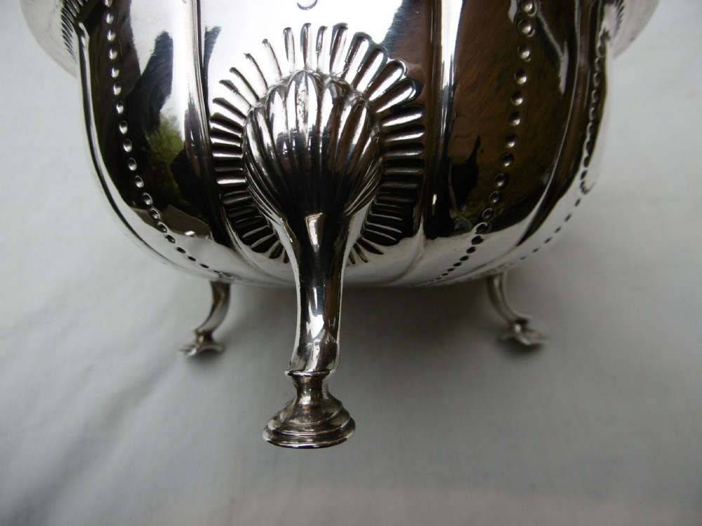 An antique George II sterling silver footed bowl featuring fluted sides, bead details, and shell-motif legs. View V