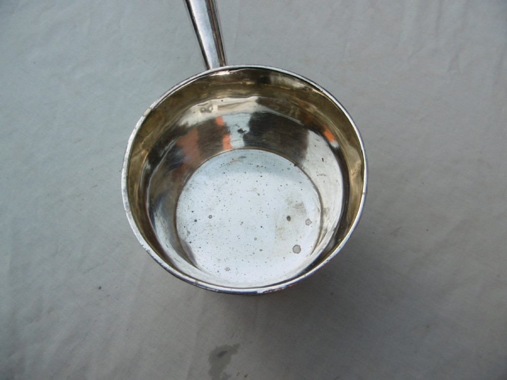 A George I silver brandy pan featuring a flared rim, plain cylindrical body, and a long turned dark wood handle. View II