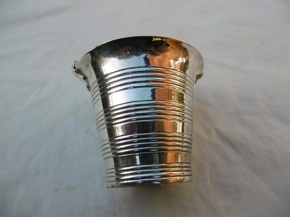 A George II sterling silver cream pail with a reeded bucket body and an overhead swing handle. View II