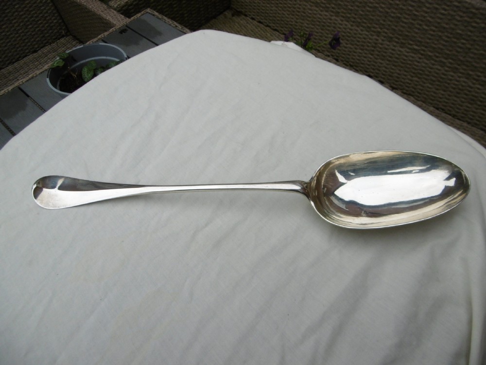 An 18th-century Georgian sterling silver hash spoon featuring a long tapered stem and a deep oval serving bowl.