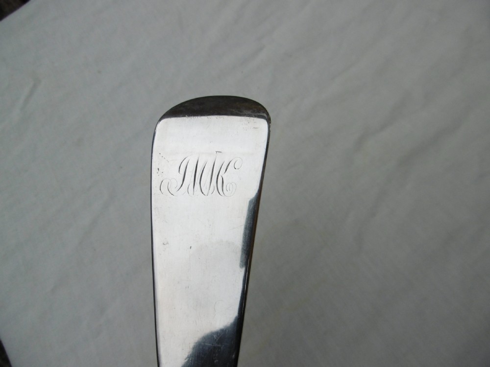 A Georgian Scottish provincial sterling silver soup ladle with a polished circular bowl and a long curved flat handle against a plain background. View III