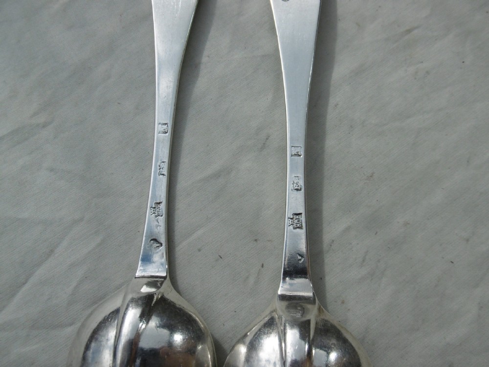 A pair of early eighteenth-century silver tablespoons displayed from the reverse, highlighting the rat-tail bowl joins, hallmarks, and initials. View II