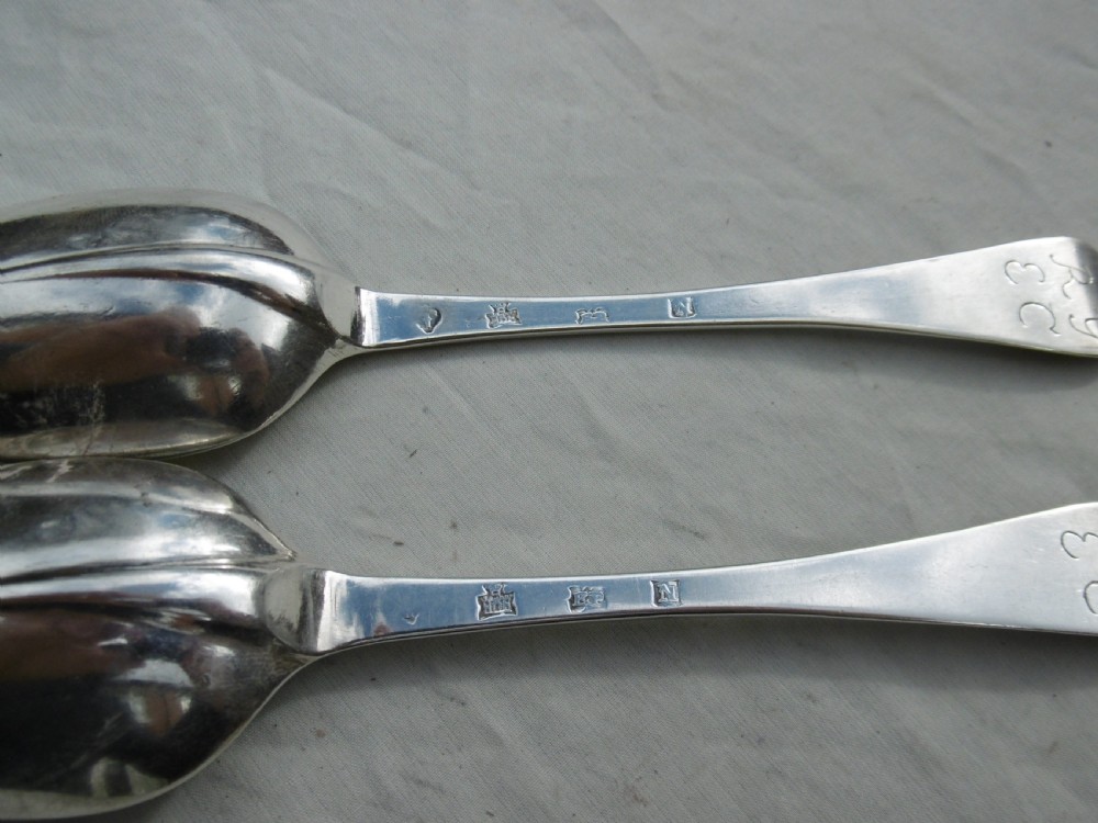 A pair of early eighteenth-century silver tablespoons displayed from the reverse, highlighting the rat-tail bowl joins, hallmarks, and initials. View III