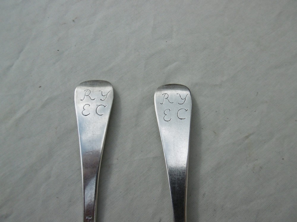 A pair of early eighteenth-century silver tablespoons displayed from the reverse, highlighting the rat-tail bowl joins, hallmarks, and initials. View IV
