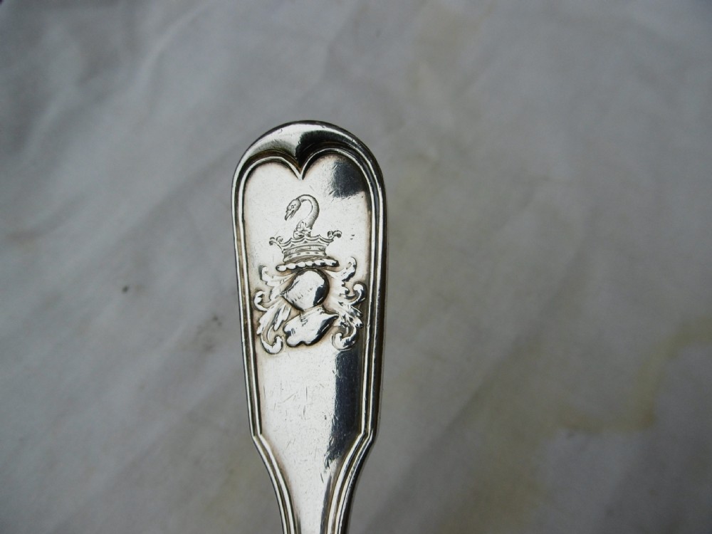 A Georgian sterling silver tablespoon featuring an engraved heraldic crest on the stem handle and an oval polished bowl. View II