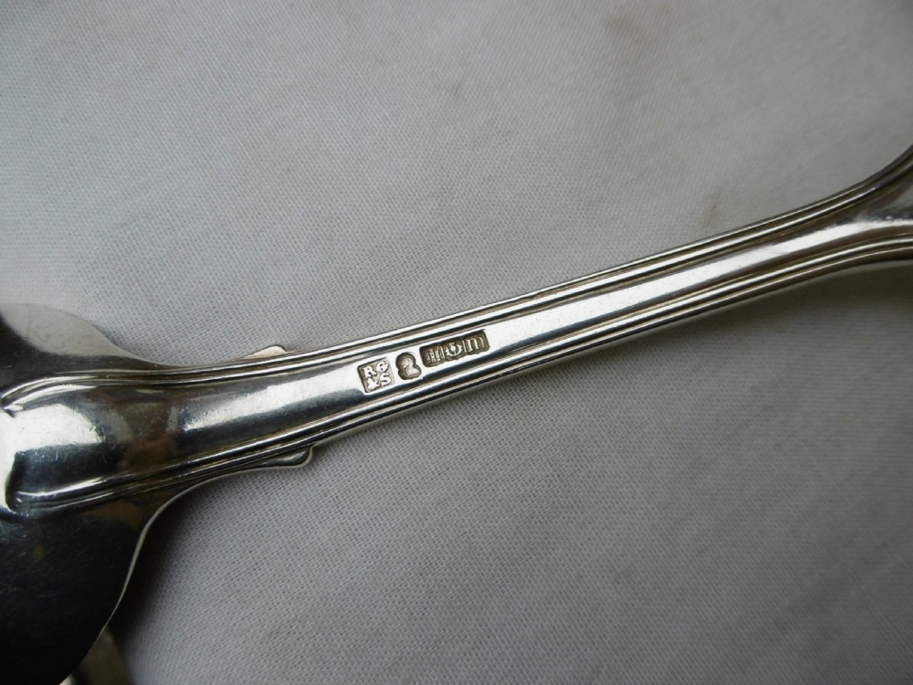 A Georgian sterling silver tablespoon featuring an engraved heraldic crest on the stem handle and an oval polished bowl. View III