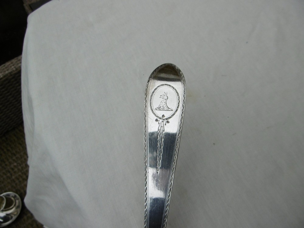 An 18th-century Georgian sterling silver soup ladle with an engraved crest on the handle and a fluted shell bowl. View III