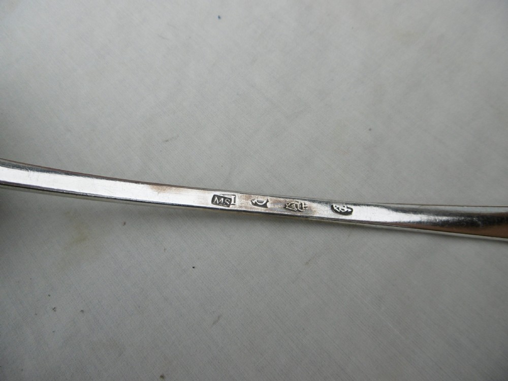 An 18th-century Georgian sterling silver soup ladle with an engraved crest on the handle and a fluted shell bowl. View IV