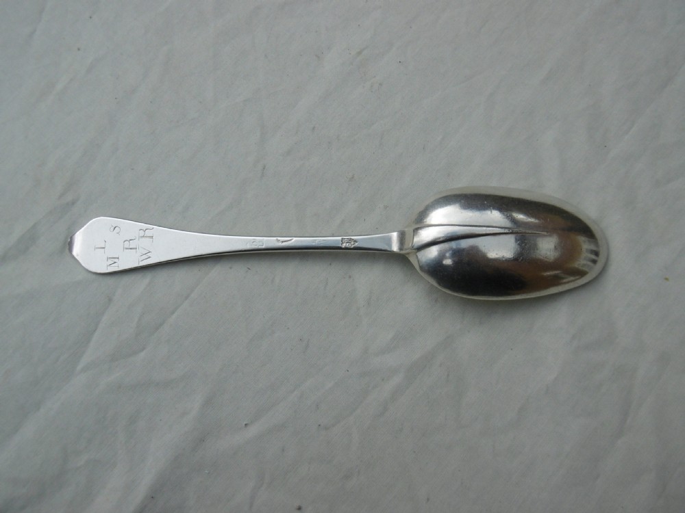 An antique 1702 Queen Anne silver dognose spoon with engraved initials on the handle and a rat-tail join on the reverse of the oval bowl.
