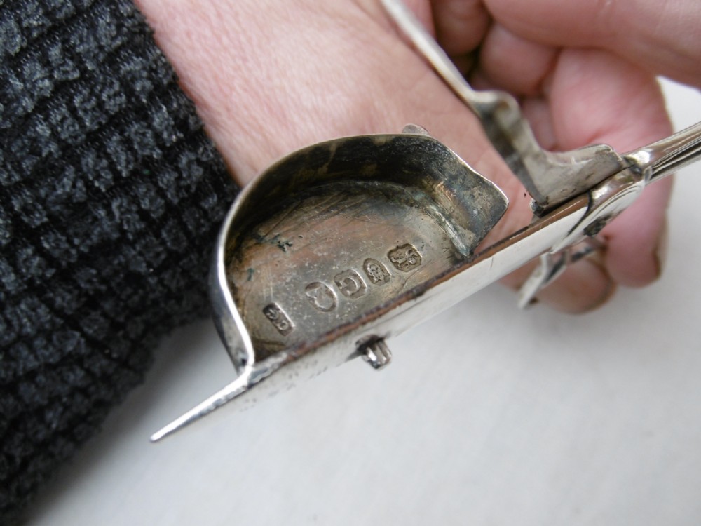 A Georgian sterling silver scissor-style candle snuffer featuring a small rectangular wick box, pointed tip, and shaped handle loops. View III