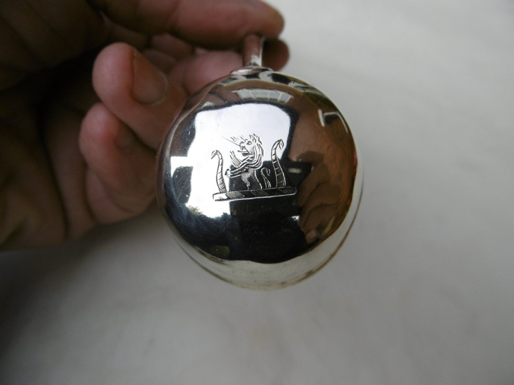 A set of six Georgian silver toddy ladles with circular bowls and dark twisted handles laid in a row. View IV
