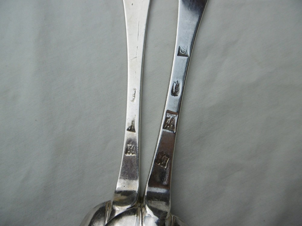 A pair of late 17th-century silver dognose tablespoons displaying rat-tail bowl supports, stem hallmarks, and engraved initials on the terminals. View III