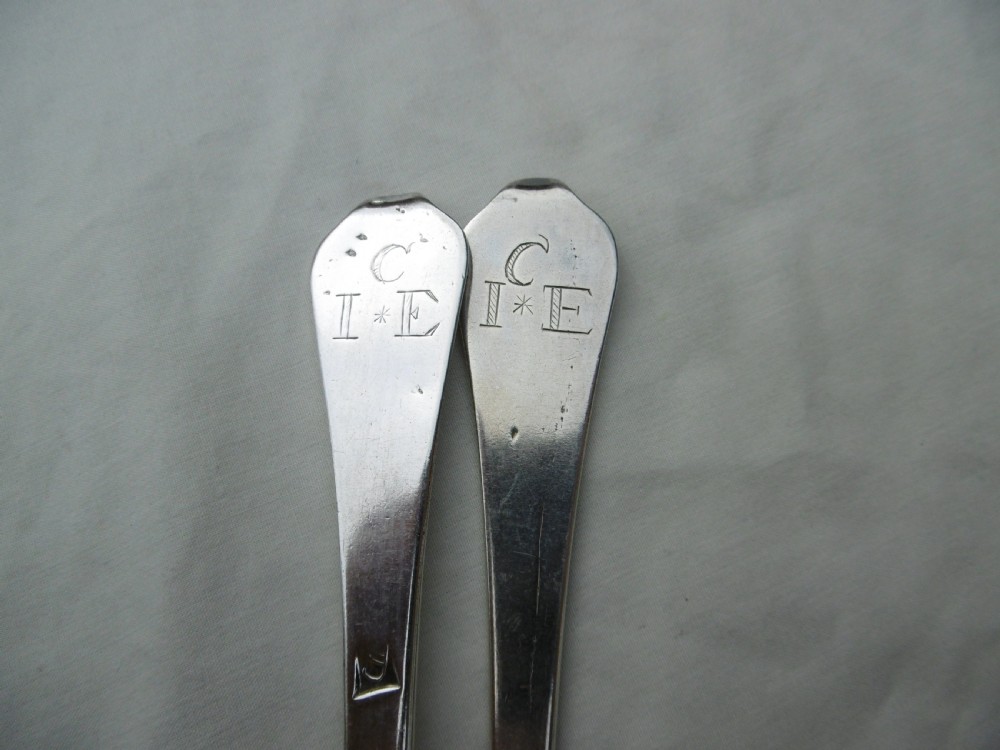 A pair of late 17th-century silver dognose tablespoons displaying rat-tail bowl supports, stem hallmarks, and engraved initials on the terminals. View IV