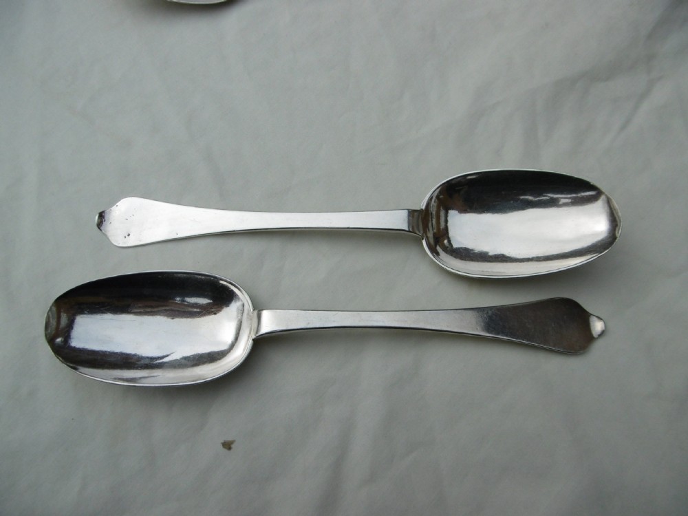 A pair of late 17th-century silver dognose tablespoons displaying rat-tail bowl supports, stem hallmarks, and engraved initials on the terminals. View VI
