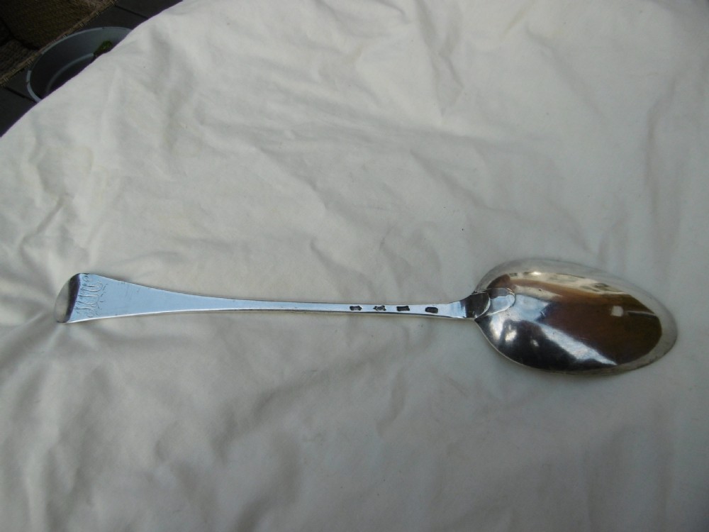 A mid-18th-century Georgian sterling silver stuffing spoon showing maker hallmarks along the slender stem and a polished oval bowl.