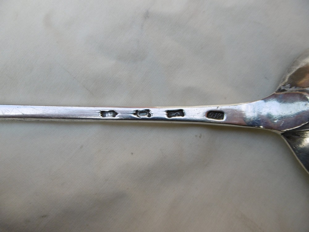 A mid-18th-century Georgian sterling silver stuffing spoon showing maker hallmarks along the slender stem and a polished oval bowl. View II